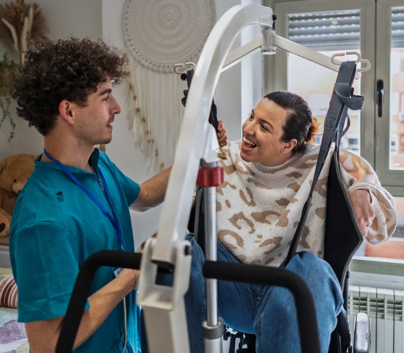 Disabled woman in hoist with male nurse