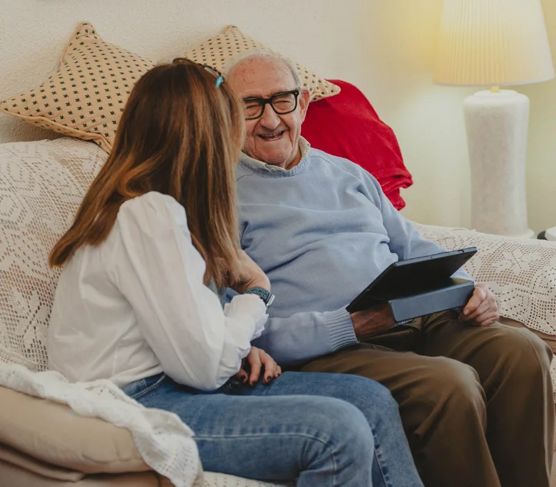 Elderly man chatting with woman on couch